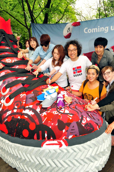 국내 론칭 7주년을 맞은 스코노코리아가 11일 홍대 직영매장을 오픈하고 일러스트레이터 밥장과 소비자들이 대형운동화에 페인팅 작업을 하는 기념 퍼포먼스를 펼치고 있다. 스코노코리아/연합뉴스