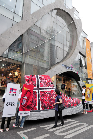 국내 론칭 7주년을 맞은 스코노코리아가 11일 홍대 직영매장을 오픈하고 일러스트레이터 밥장과 소비자들이 대형운동화에 페인팅 작업을 하는 기념 퍼포먼스를 펼치고 있다. 스코노코리아/연합뉴스