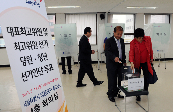 새누리당 새 지도부 선출을 위한 전당대회를 하루 앞둔 14일 서울 영등포구 선거관리위원회에 마련된 투표소에서 선거인단으로 사전 등록한 당원들이 투표를 하고 있다. 뉴스1