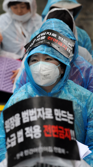 14일 오후 봄비가 내리는 가운데 서울 종로구 보건복지부 앞 원서공원에서 민간어린이집연합회 회원들이 민간 어린이집에 대한 규제 완화를 촉구하는 집회를 갖고 있다. 도준석기자 pado@seoul.co.kr