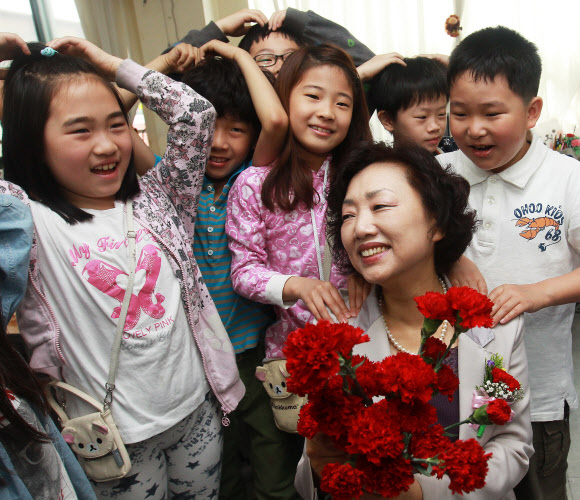 스승의날인 15일 오전 서울 마포구 아현동 소의초등학교 3학년 1반 학생들이 담임선생님에게 카네이션을 달아주며 ‘선생님 사랑해요’를 외치고 있다.  연합뉴스