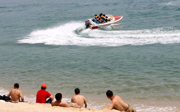 여름 기온을 보인 20일 강원 강릉시 경포 해변을 찾은 관광객들이 시원한 바닷바람에 무더위를 식히고 있다.  연합뉴스
