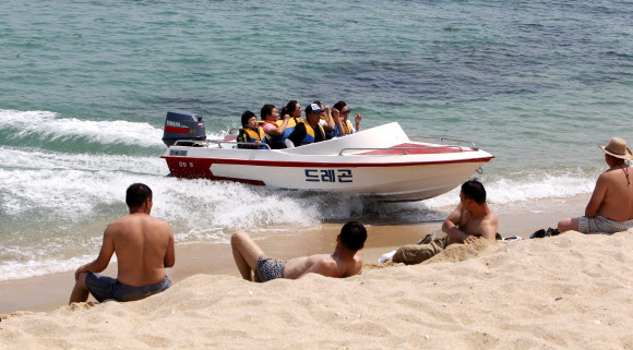 여름 기온을 보인 20일 강원 강릉시 경포 해변을 찾은 관광객들이 시원한 바닷바람에 무더위를 식히고 있다.  연합뉴스
