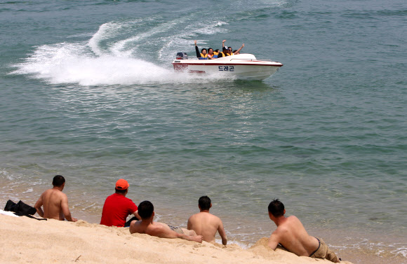 여름 기온을 보인 20일 강원 강릉시 경포 해변을 찾은 관광객들이 시원한 바닷바람에 무더위를 식히고 있다.  연합뉴스