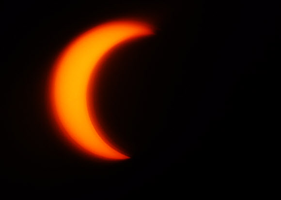 부분일식이 시작된 21일 오전 서울 북악 스카이웨이에서 바라본 태양이 달에 가려져 초승달 모양을 이루고 있다. 이번 부분일식은 오전 6시23분부터 8시48분까지 진행되며 오전 7시 32분경에는 태양의 80%까지 가려진다. 연합뉴스