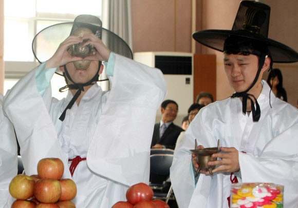 성년의 날을 맞은 21일 제주시 청소년수련관에서 열린 제주향교 주관 전통 성년식에서 성년을 맞은 학생들이 어른 앞에서 술을 마시는 법을 배우는 초례를 하고 있다. 연합뉴스