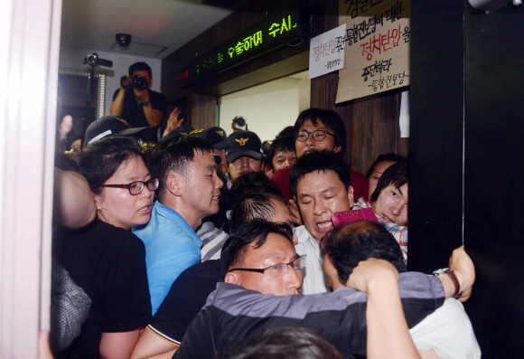 21일 밤 통합진보당 당원 명부 서버가 있는 서울 금천구 가산동의 인터넷업체 ㈜스마일서브 사무실 입구에서 압수수색이 진행되는 동안 당원들이 경찰과 몸싸움을 벌이고 있다.  정연호기자 tpgod@seoul.co.kr