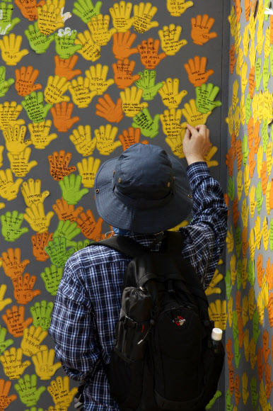 노무현 전 대통령 3주기인 23일 경남 김해 봉하마을에서 추모객이 고인을 그리는 사연을 적은 쪽지를 게시판에 붙이고 있다. 이 게시판에는 고인과의 추억이나 그리움을 등을 담은 쪽지가 빼곡하게 붙어 추모 분위기를 고조시키고 있다. 연합뉴스