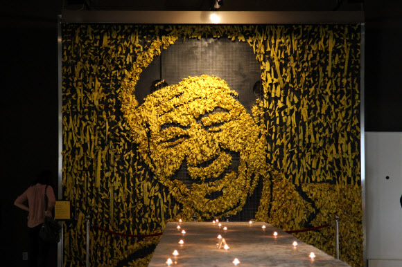 노무현 전 대통령의 3주기를 맞아 23일 경남 김해시 봉하마을 추모관에서  한 추모객이 노란 리본으로 만든 고인의 모습을 바라보고 있다.  연합뉴스