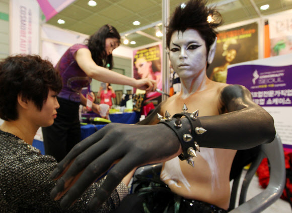 24일 오전 서울 삼성동 코엑스에서 열린 ‘서울국제 화장품·미용 산업박람회’에서 한 참가업체가 바디페인팅 시연을 하고 있다.  연합뉴스