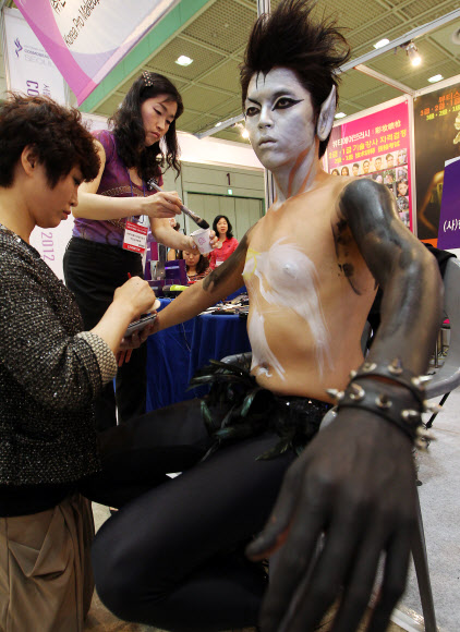 24일 오전 서울 삼성동 코엑스에서 열린 ‘서울국제 화장품·미용 산업박람회’에서 한 참가업체가 바디페인팅 시연을 하고 있다.  연합뉴스