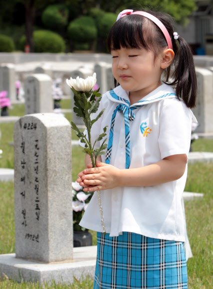 호국보훈의 달을 맞은 6월의 첫 날인 1일 서울 동작구 국립현충원을 찾은 관내 유치원생들이 묘역 앞에서 두 손을 모은채 묵념을 하고 있다.  연합뉴스