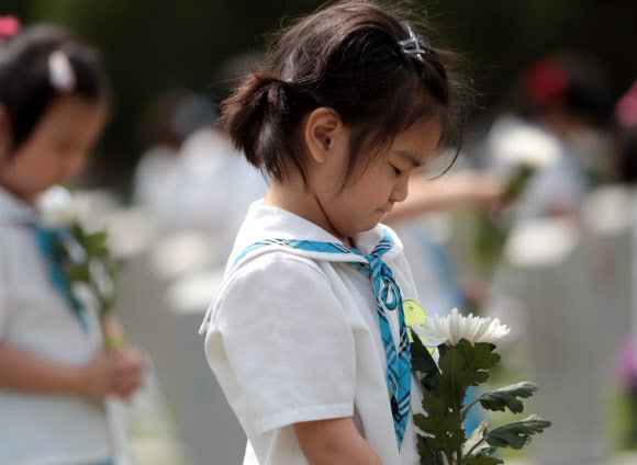 호국보훈의 달을 맞은 6월의 첫 날인 1일 서울 동작구 국립현충원을 찾은 관내 유치원생들이 묘역 앞에서 두 손을 모은채 묵념을 하고 있다.  연합뉴스