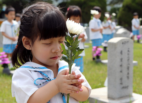 호국보훈의 달을 맞은 6월의 첫 날인 1일 서울 동작구 국립현충원을 찾은 관내 유치원생들이 묘역 앞에서 두 손을 모은채 묵념을 하고 있다.  연합뉴스