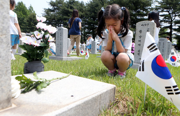 호국보훈의 달을 맞은 6월의 첫 날인 1일 서울 동작구 국립현충원을 찾은 관내 유치원생들이 묘역 앞에서 두 손을 모은채 묵념을 하고 있다.  연합뉴스