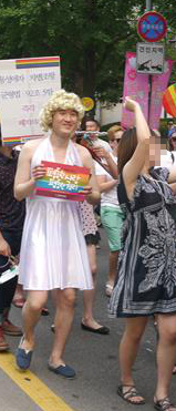 지난 2일 서울 종로구 청계천로에서 열린 제13회 퀴어퍼레이드에 참가한 배경헌(왼쪽) 기자가 메릴린 먼로 분장을 하고 ‘평등한 사랑, 평등한 권리’라고 쓴 카드를 들고 걷고 있다.