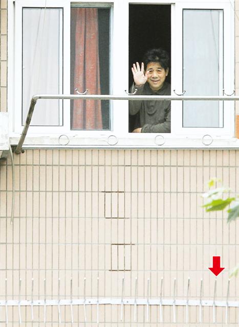 가택연금 상태인 펑정후가 자신의 집 창을 열고 손을 흔들어 보이고 있다. 명보 제공