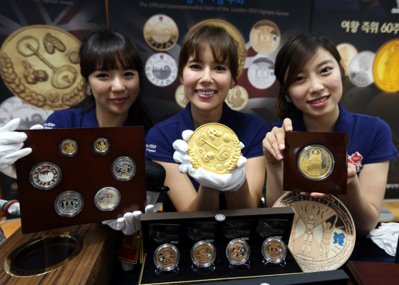 14일 서울 중구 정동 영국대사관에서 화동양행이 런던올림픽과 영국여왕 즉위 60주년을 기념하기 위해 출시된 1Kg 대형금화와 은화를 선보이고 있다. 연합뉴스