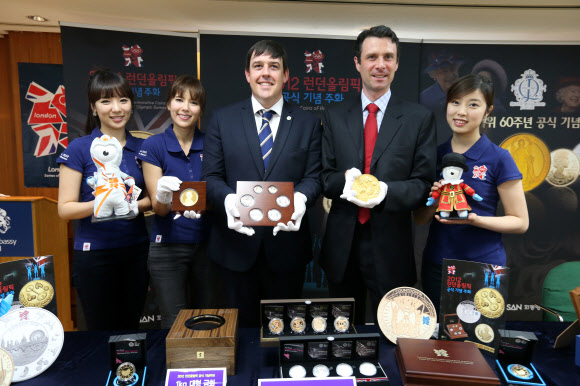 4일 서울 중구 정동 영국대사관에서  앤드류 댈글리시(오른쪽에서 두번째) 주한영국대사 대리와 모델들이  런던올림픽과 영국여왕 즉위 60주년을 기념하기 위해 출시된 1Kg 대형 금화와 은화를 선보이고 있다. 연합뉴스