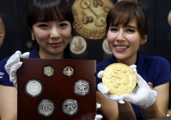 14일 서울 중구 정동 영국대사관에서 화동양행이 런던올림픽과 영국여왕 즉위 60주년을 기념하기 위해 출시된 1Kg 대형금화와 은화를 선보이고 있다. 연합뉴스