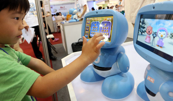 14일 오후 서울 양재동 aT센터에서 열린 ‘2012 베이비 키즈 페어’에서 한 아이가 ‘키봇2’를 즐기고 있다. 연합뉴스