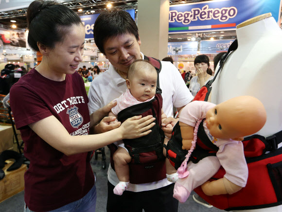 14일 오후 서울 양재동 aT센터에서 열린 ‘2012 베이비 키즈 페어’에서 한 관람객이 아이를 편안하게 안을 수 있는 힙시트를 착용해 보고 있다. 연합뉴스