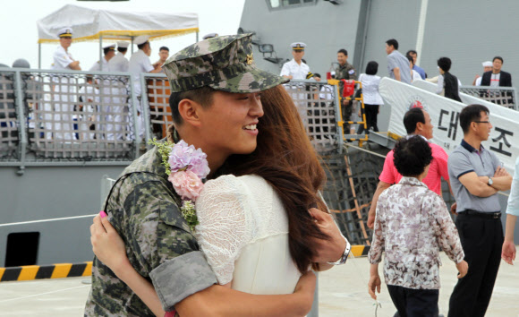 우리 선박의 해상 안전보장을 위해 소말리아 해역으로 파병된 청해부대 9진 대조영함이 6개월간의 임무를 마치고 15일 해군 부산작전기지에 무사히 귀환했다. 한 청해부대원이 환영나온 여자친구와 감격의 포옹을 하고 있다.  연합뉴스