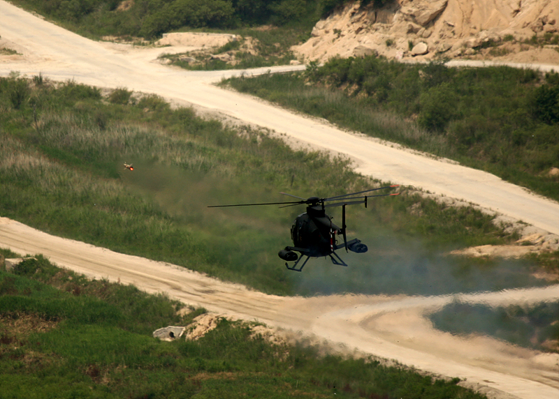 적 전차부대를 발견한 500MD디펜더 경공격헬기가 TOW대전차미사일을 발사하여 적 전차를 격파하고 있다.