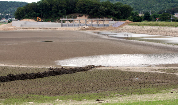 26일 극심한 가뭄이 이어지는 가운데 인천 강화군 내가면 고려저수지에 물이 말라 바닥이 드러나자 수로공사가 진행되지 못하고 있다.  연합뉴스
