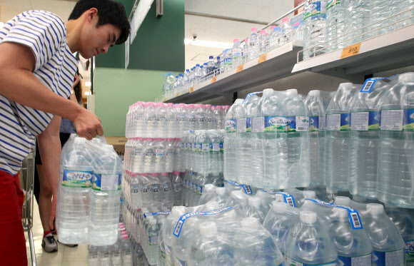 26일 오전 서울 시내 한 대형마트를 찾은 시민들이 생수를 집어들고 있다. 26일 이마트에 따르면 올해 들어 지난 24일까지 음료 매출 구성비에서 국산 생수가 과일·야채음료, 탄산음료를 제치고 1위에 올랐다. 생수가 잘 팔린 이유는 올해 황사가 없었고 비가 자주 오지 않자 야외활동 인구가 폭발적으로 늘면서 나들이 필수품으로 애용됐기 때문이라고 이마트는 분석했다. 연합뉴스