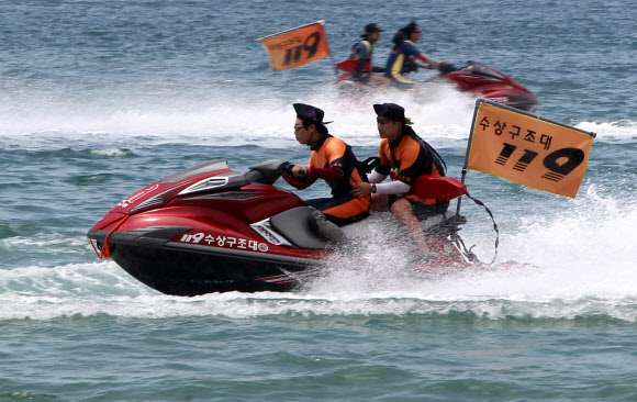 29일 부산 해운대해수욕장에서 열린 ‘2012 전국 119 시민수상구조대 발대식’에서 119수상구조대원이 수상오토바이를 타고 익수자 발생장소로 신속히 이동하고 있다.  연합뉴스