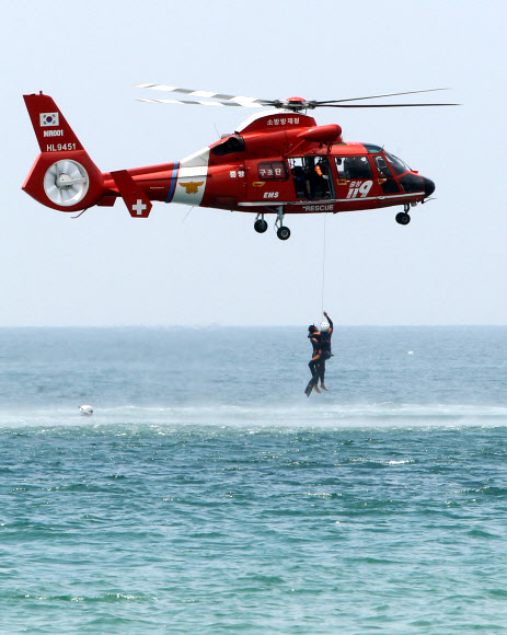 29일 부산 해운대해수욕장에서 열린 ‘2012 전국 119 시민수상구조대 발대식’에서 소방헬기가 조난자를 구조하는 시범을 선보이고 있다.  연합뉴스