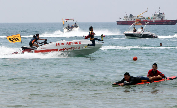 29일 부산 해운대해수욕장에서 열린 ‘2012 전국 119 시민수상구조대 발대식’에서 119수상구조대원이 물에 빠진 사람을 구조하는 시범을 선보이고 있다. 연합뉴스