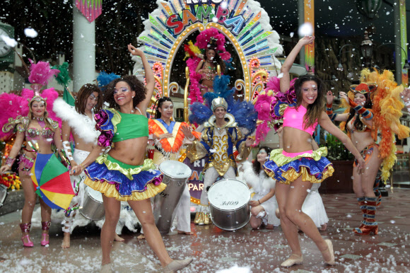 5일 서울 잠실 롯데월드에서 삼바댄서들이 인공눈을 맞으며 화려한 공연을 펼치고 있다.  연합뉴스