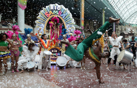 5일 서울 잠실 롯데월드에서 삼바댄서들이 인공눈을 맞으며 화려한 공연을 펼치고 있다.  연합뉴스