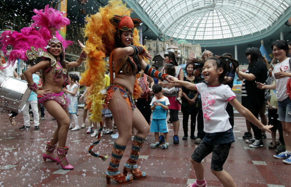 5일 서울 잠실 롯데월드에서 삼바댄서들이 어린이들과 함께 인공눈을 맞으며 화려한 공연을 펼치고 있다.  연합뉴스