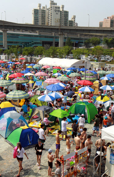 무더운 날씨를 보인 8일 오후 서울 뚝섬 한강수영장에서 시민들이 피서를 즐기고 있다. 연합뉴스