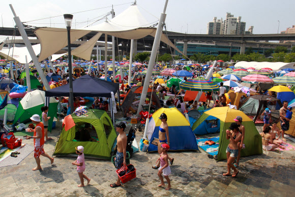 무더운 날씨를 보인 8일 오후 서울 뚝섬 한강수영장에서 시민들이 피서를 즐기고 있다. 연합뉴스