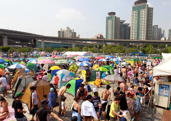 무더운 날씨를 보인 8일 오후 서울 뚝섬 한강수영장에서 시민들이 피서를 즐기고 있다. 연합뉴스