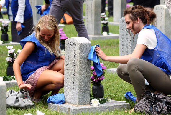 9일 오전 서울 동작동 국립서울현충원에서 UN 참전국 청소년 평화캠프 참가자들이 참전용사 묘역에서 묘비를 닦고 있다. 국가보훈처가 주관한 이번 캠프에 참가한 15개국 147명의 대학생들은 6박 7일간 현충원 참배, 땅굴 견학, 병영체험 등을 경험한다. 연합뉴스