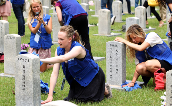9일 오전 서울 동작동 국립서울현충원에서 UN 참전국 청소년 평화캠프 참가자들이 참전용사 묘역에서 묘비를 닦고 있다. 국가보훈처가 주관한 이번 캠프에 참가한 15개국 147명의 대학생들은 6박 7일간 현충원 참배, 땅굴 견학, 병영체험 등을 경험한다. 연합뉴스