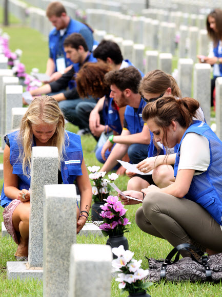 9일 오전 서울 동작동 국립서울현충원에서 UN 참전국 청소년 평화캠프 참가자들이 참전용사 묘역에서 직접 작성한 편지를 펴들고 있다. 연합뉴스