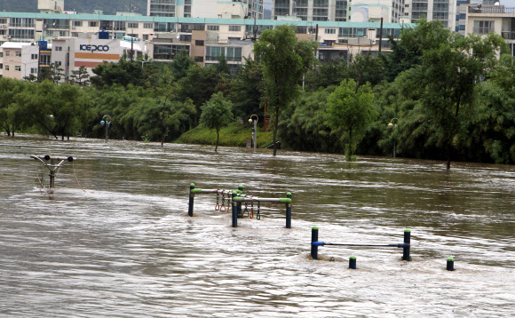 부산 지역에 188mm비가 내린 15일 오후 부산 연제구 온천천의 물이 범람하면서 온천천 주변에 설치돼있던 운동시설이 물에 잠겨있다.  연합뉴스