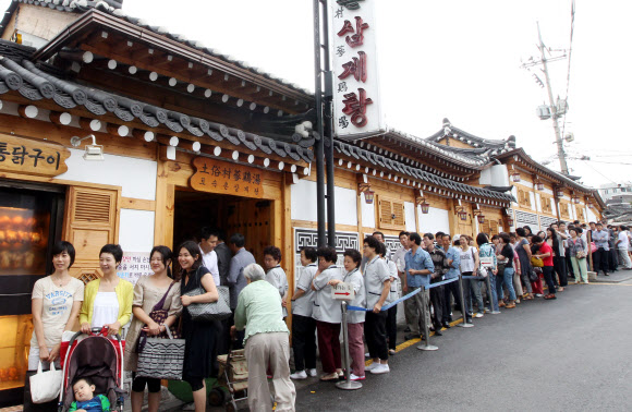 초복을 이틀앞둔 16일 서울 종로구 한 삼계탕전문점을 찾은 시민들과 관광객들이 줄지어 순서를 기다리고 있다. 연합뉴스