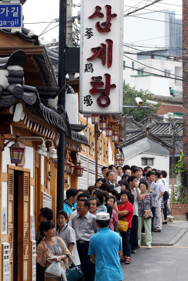 초복을 이틀앞둔 16일 서울 종로구 한 삼계탕전문점을 찾은 시민들과 관광객들이 줄지어 순서를 기다리고 있다. 연합뉴스