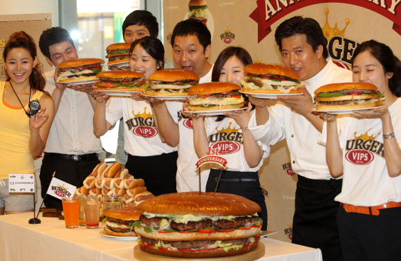17일 오전 서울 동대문구  CJ 제일제당센터 1층에서 열린 ‘직원 빅버거 먹기 대회’에서 모델과 임직원들이 햄버거를 들고 포즈를 취하고 있다. 연합뉴스