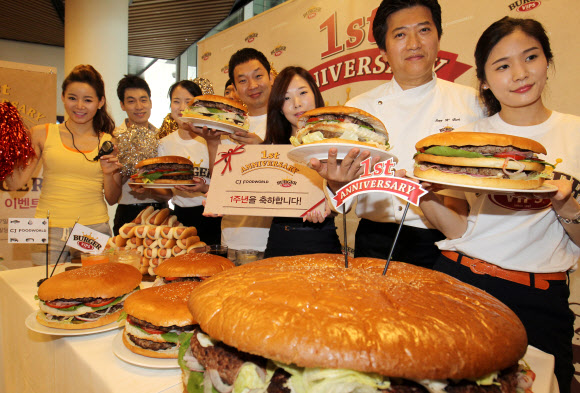 17일 오전 서울 동대문구  CJ 제일제당센터 1층에서 열린 ‘직원 빅버거 먹기 대회’에서 모델과 임직원들이 햄버거를 들고 포즈를 취하고 있다. 연합뉴스