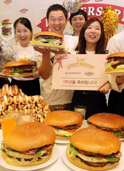 17일 오전 서울 동대문구  CJ 제일제당센터 1층에서 열린 ‘직원 빅버거 먹기 대회’에서 모델과 임직원들이 햄버거를 들고 포즈를 취하고 있다.  연합뉴스