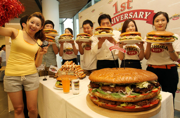 17일 오전 서울 동대문구  CJ 제일제당센터 1층에서 열린 ‘직원 빅버거 먹기 대회’에서 모델과 임직원들이 햄버거를 들고 포즈를 취하고 있다. 연합뉴스