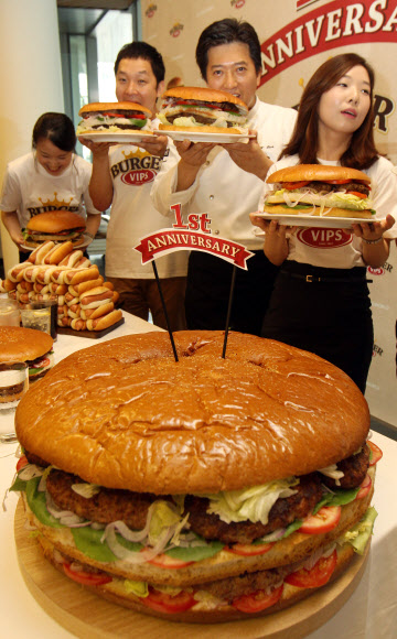 17일 오전 서울 동대문구  CJ 제일제당센터 1층에서 열린 ‘직원 빅버거 먹기 대회’에서 모델과 임직원들이 햄버거를 들고 포즈를 취하고 있다. 연합뉴스